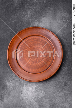 Empty ceramic plate on a dark textured background 117692001