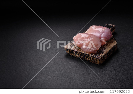 Fresh chicken fillet on a dark concrete table with spices and herbs Fresh chicken fillet on a dark concrete table with spices and herbs 117692033