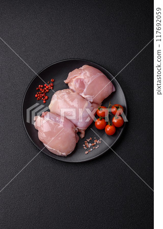 Fresh chicken fillet on a dark concrete table with spices and herbs Fresh chicken fillet on a dark concrete table with spices and herbs 117692059