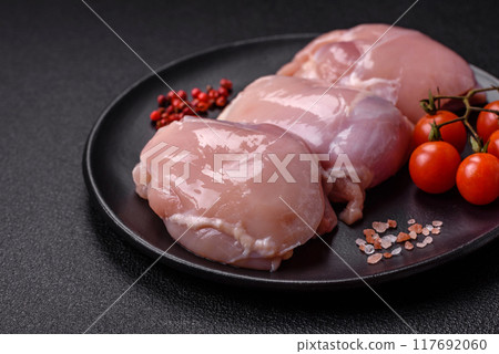 Fresh chicken fillet on a dark concrete table with spices and herbs Fresh chicken fillet on a dark concrete table with spices and herbs 117692060