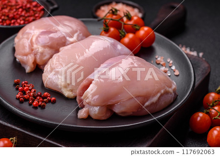 Fresh chicken fillet on a dark concrete table with spices and herbs Fresh chicken fillet on a dark concrete table with spices and herbs 117692063