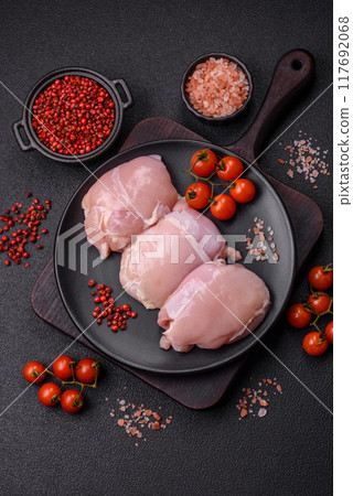 Fresh chicken fillet on a dark concrete table with spices and herbs Fresh chicken fillet on a dark concrete table with spices and herbs 117692068
