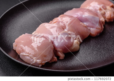 Fresh chicken fillet on a dark concrete table with spices and herbs Fresh chicken fillet on a dark concrete table with spices and herbs 117692072