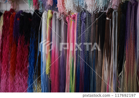 Bright colored pigtails of zizi from kanekalon. Artificial hair for braiding Afro-pigtails and hairstyles. Bright colors. Textured wallpaper. With space to copy. High quality photo 117692197