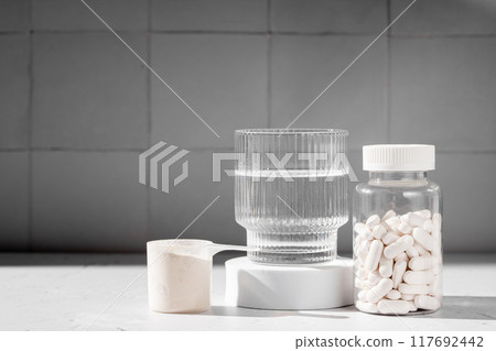 Food supplement concept. Capsules of probiotics, vitamins, white pills and a scoop of protein collagen powder. Food supplement concept. Capsules of probiotics, vitamins, white pills and a scoop of protein collagen powder. 117692442