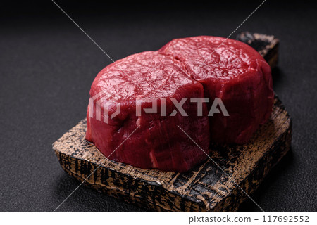 Fresh juicy raw beef medallions with salt and spices 117692552
