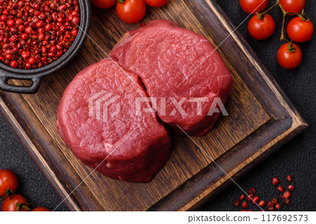 Fresh juicy raw beef medallions with salt and spices Fresh juicy raw beef medallions with salt and spices 117692573