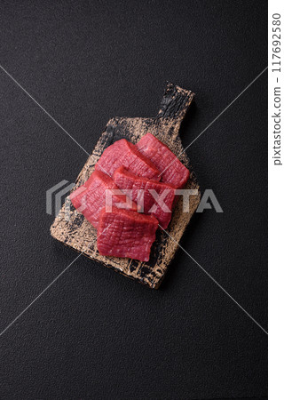 Juicy fresh raw beef meat with salt, spices and herbs Juicy fresh raw beef meat with salt, spices and herbs 117692580