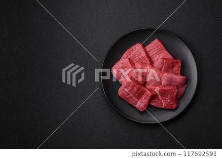 Juicy fresh raw beef meat with salt, spices and herbs Juicy fresh raw beef meat with salt, spices and herbs 117692591