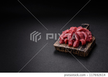 Juicy fresh raw beef meat with salt, spices and herbs Juicy fresh raw beef meat with salt, spices and herbs 117692614