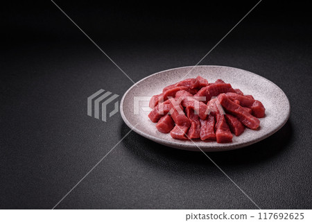 Juicy fresh raw beef meat with salt, spices and herbs Juicy fresh raw beef meat with salt, spices and herbs 117692625
