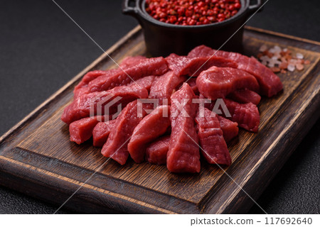 Juicy fresh raw beef meat with salt, spices and herbs Juicy fresh raw beef meat with salt, spices and herbs 117692640