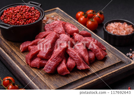Juicy fresh raw beef meat with salt, spices and herbs Juicy fresh raw beef meat with salt, spices and herbs 117692643