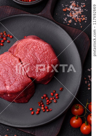 Fresh juicy raw beef medallions with salt and spices Fresh juicy raw beef medallions with salt and spices 117692669