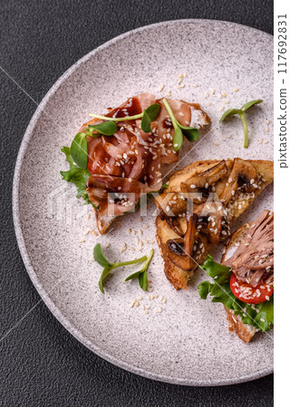 Variation of several toasts or bruschetta with prosciutto, mushrooms and veal 117692831