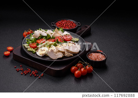 Delicious fresh caesar salad in a bowl with chicken breast, egg, tomatoes 117692888