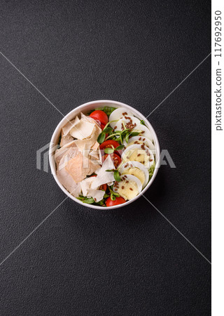 Delicious fresh caesar salad in a bowl with chicken breast, egg, tomatoes 117692950