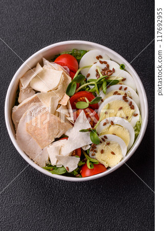 Delicious fresh caesar salad in a bowl with chicken breast, egg, tomatoes 117692955
