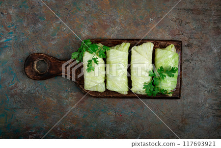 raw cabbage rolls, not cooked, with minced meat, top view, without people, in the spotlight. raw cabbage rolls, not cooked, with minced meat, top view, without people, in the spotlight. 117693921