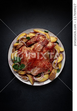fried, baked chicken, in the oven, with spices, and rustic potatoes, top view, homemade, 117694027