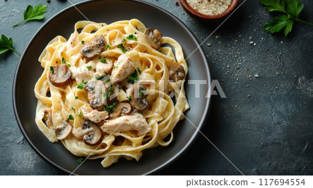 Creamy fettuccine Alfredo with mushrooms and chicken on a dark rustic table 117694554