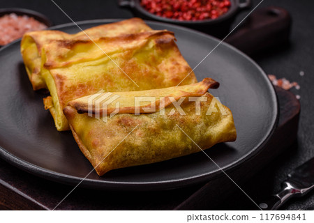 Homemade fried pancakes with filling on a ceramic plate 117694841