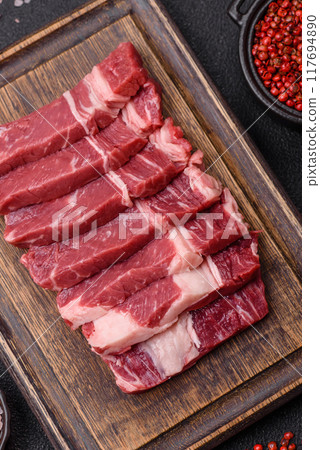 Fresh raw beef cut into slices with salt, spices 117694890