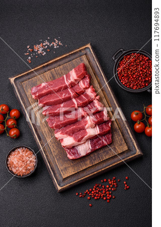 Fresh raw beef cut into slices with salt, spices Fresh raw beef cut into slices with salt, spices 117694893