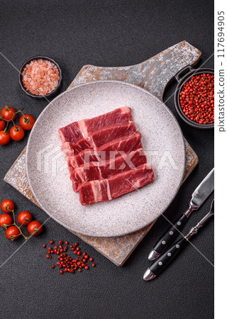Fresh raw beef cut into slices with salt, spices Fresh raw beef cut into slices with salt, spices 117694905