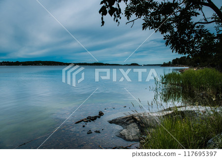 Midnight sea sky in Sweden during light summer nights. 117695397