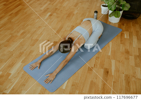 Engaging in a relaxing yoga pose promotes mindfulness and enhances flexibility in the body 117696677