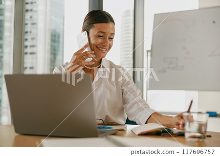 A Professional Businesswoman Engaged in Work within a Modern Office Setting and Environment 117696757