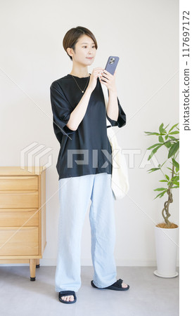 The whole body of a woman operating a smartphone The whole body of a woman operating a smartphone 117697172