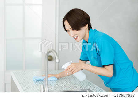 一位來自家事服務部門的女士正在打掃廚房 一位來自家事服務部門的女士正在打掃廚房 117697638