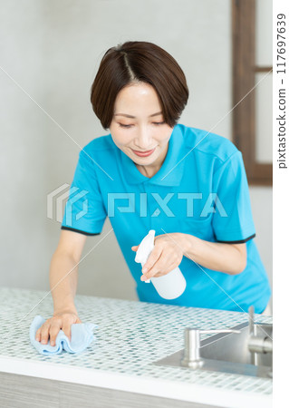 一位來自家事服務部門的女士正在打掃廚房 一位來自家事服務部門的女士正在打掃廚房 117697639