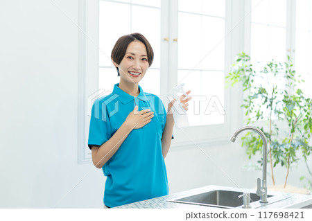 A woman from a housekeeping service cleaning the kitchen 117698421