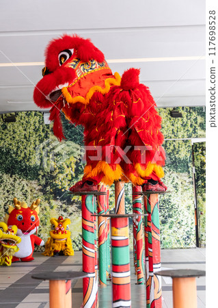 Two lions performing dances on pillars as part of Chinese cultural performance. 117698528