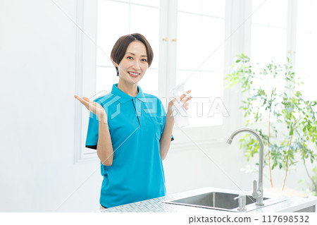 A woman from a housekeeping service cleaning the kitchen A woman from a housekeeping service cleaning the kitchen 117698532