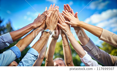 A diverse group of hands interlock, representing unity and a shared commitment to achieving a common goal. 117699507