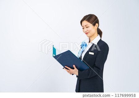 A middle-aged woman in a suit serving customers while holding a file A middle-aged woman in a suit serving customers while holding a file 117699958
