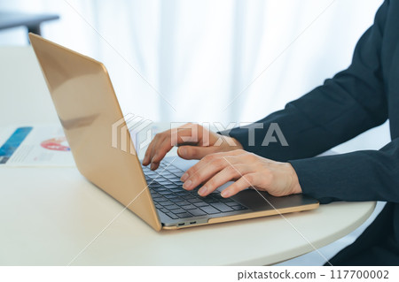 Female business person using a laptop in the office Female business person using a laptop in the office 117700002