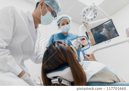 Asian dental professionals provide oral care and service to a female patient 117701668