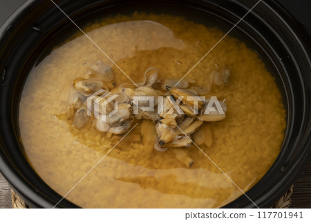 Clam rice. Clam rice cooked in a clay pot. Put clam seasoning into the clay pot. Clam rice. Clam rice cooked in a clay pot. Put clam seasoning into the clay pot. 117701941