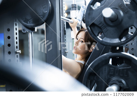 Young woman training in a sports gym 117702009