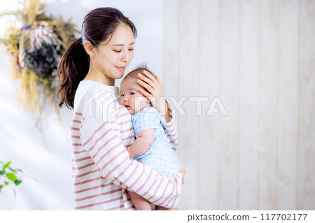 A mother holding a baby 117702177