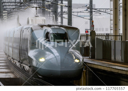 The Kyushu Shinkansen Sakura train passing Chikugo-Funagoya Station in the rain The Kyushu Shinkansen Sakura train passing Chikugo-Funagoya Station in the rain 117705557