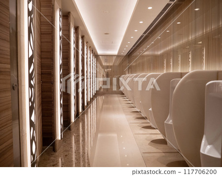 Modern public restroom with sleek white urinals and elegant lighting at night Modern public restroom with sleek white urinals and elegant lighting at night 117706200