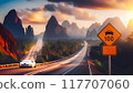 A high-speed highway in a picturesque mountainous area. There is a road sign on the side of the road warning about the speed limit 117707060