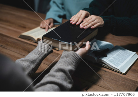 Asian men and women hands praying to god with the bible. Pray for god blessing. Religious beliefs Christian life crisis prayer to god. 117707906