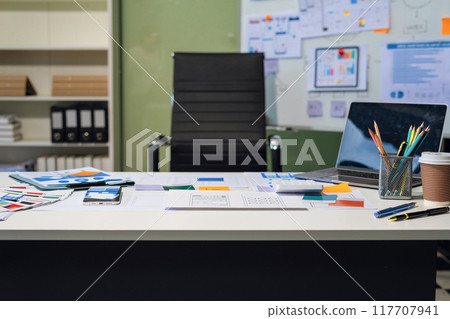 Workspace area with laptop tablet smartphone and paperwork on the table in the office concept. Workspace area with laptop tablet smartphone and paperwork on the table in the office concept. 117707941